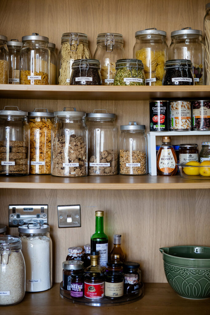 The Kitchen Edit: Pantry and Cupboard Organising Neatly arranged jars and kitchen essentials on open shelves, showing a beautifully organised and easy-to-maintain pantry space.